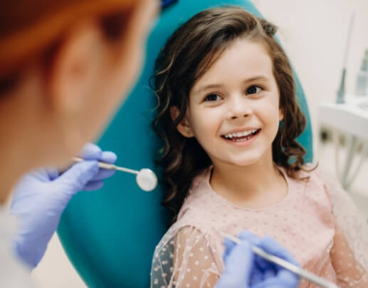 Smiling child receiving dental checkup and teeth cleaning