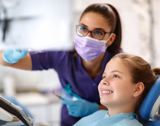 Child and dental team member talking during children's dental checkup and teeth cleaning visit