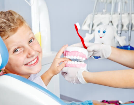 Smiling young dental patient learning to brush and floss correctly