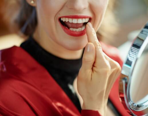 Dental patient pointing to smile after cosmetic dental bonding