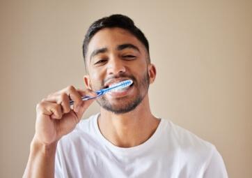 Man brushing teeth to prevent dental emergencies