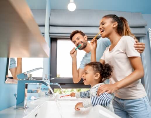 Family brushing teeth together to prevent dental emergencies
