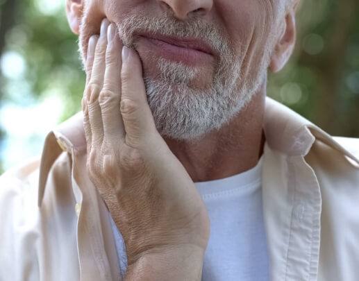 Man in pain experiencing signs and symptoms of oral cancer