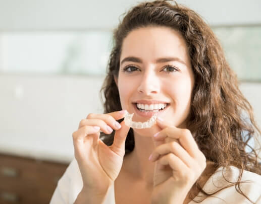 Woman placing Sure Smile clear braces tray