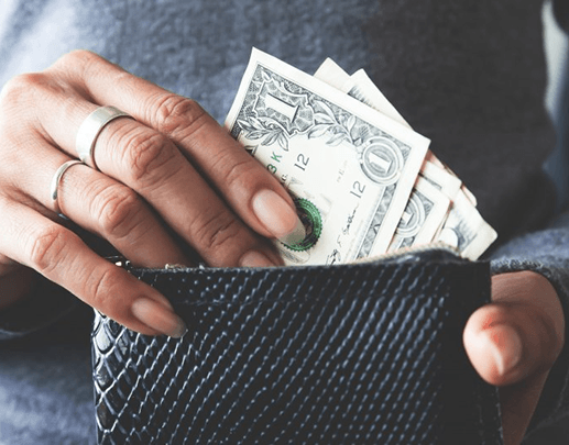 a person picking out money from a wallet